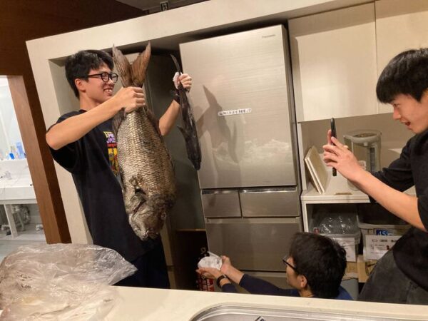 釣った魚を寮の友人に披露する様子.jpg