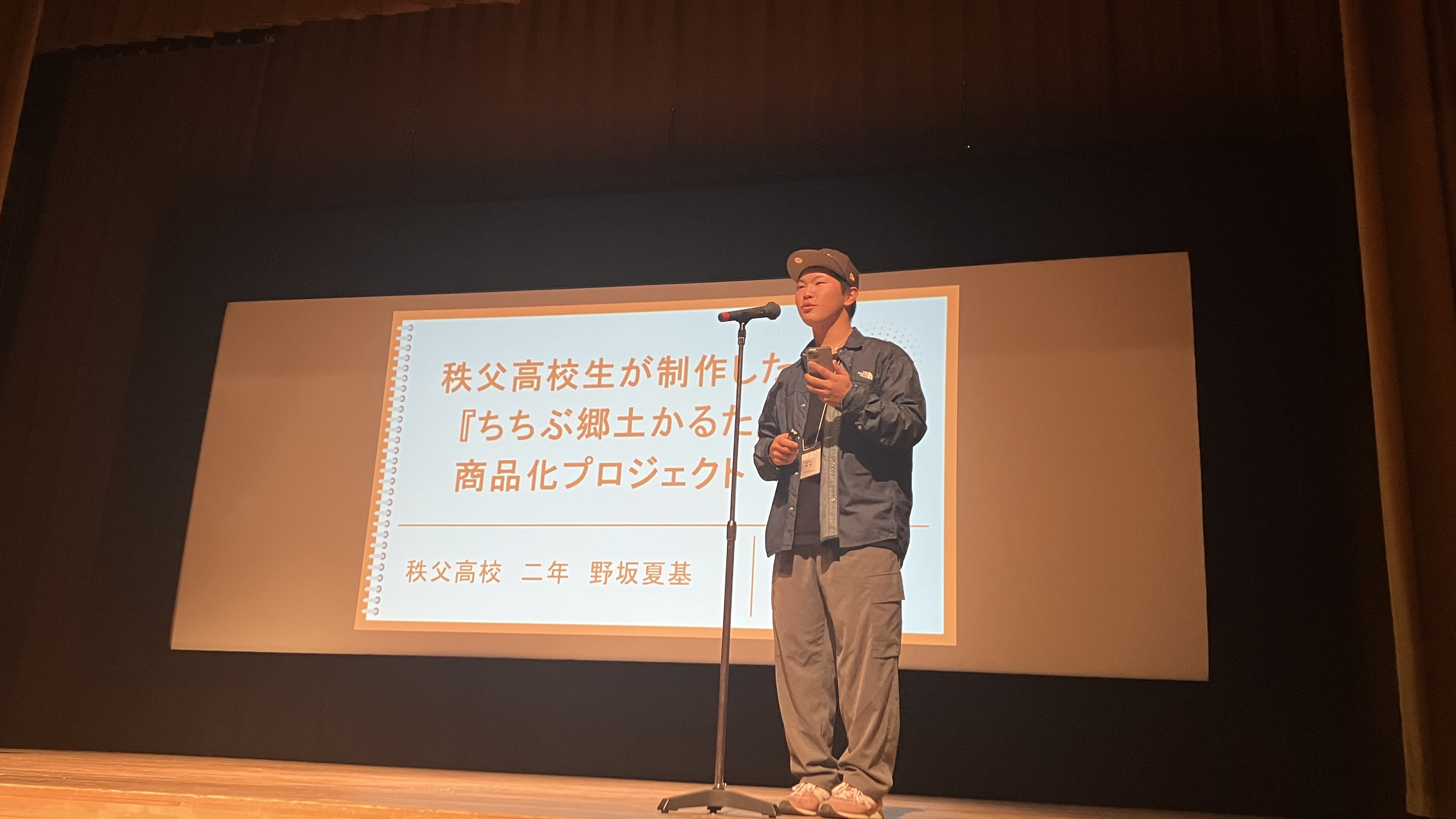 「よこらぼ大会議2025」で150名を超える聴衆を前に地元・横瀬への想いを語る野坂さん.jpg